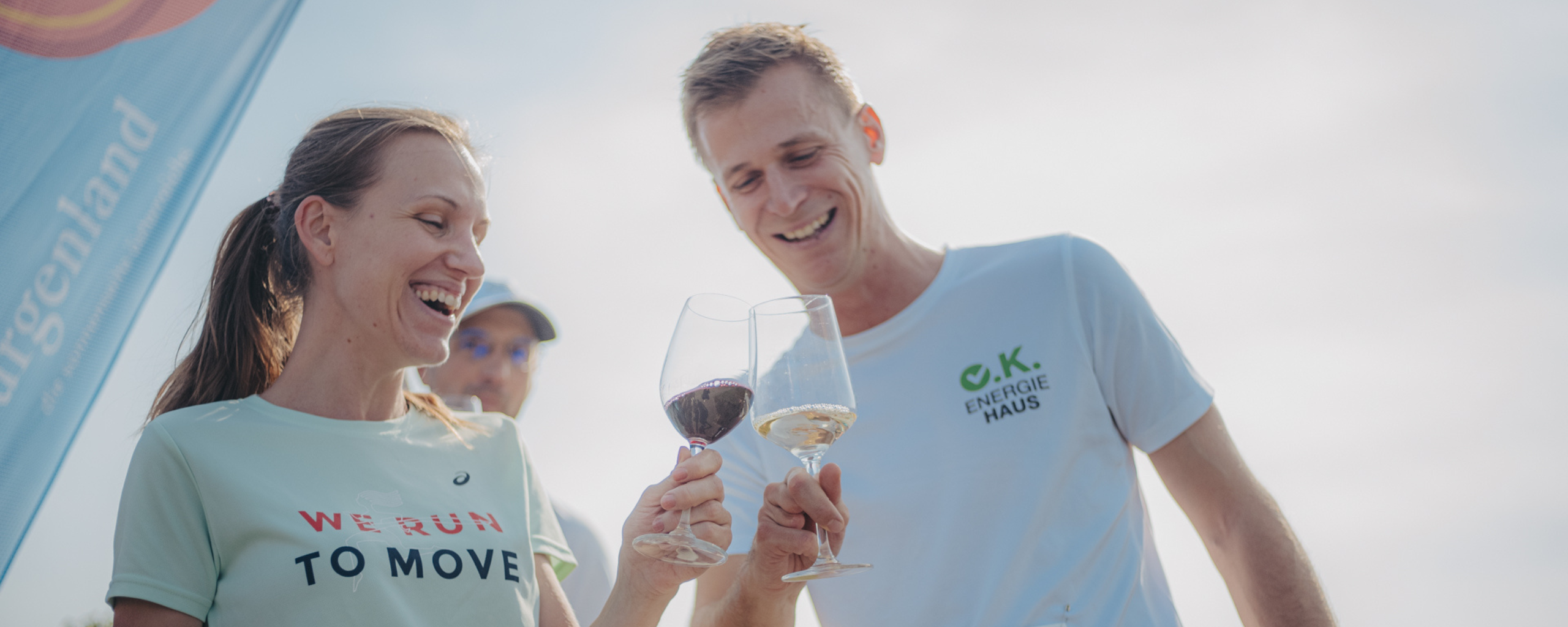 Läuferin und Läufer stoßen mit einem Glas Wein beim Blaufränkischland Marathon an